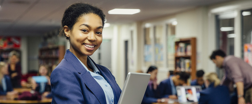 “teacher-at-desk-in-classroom“