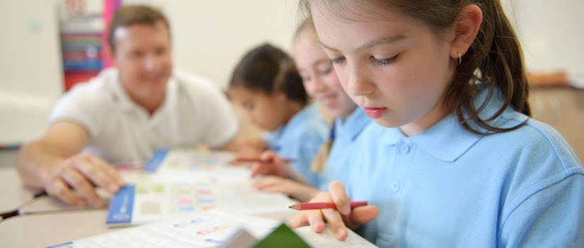 “student-working-at-desk-in-classroom“